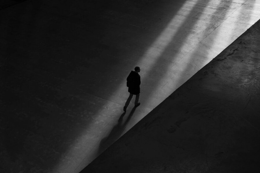A man walks alone in a dark environment