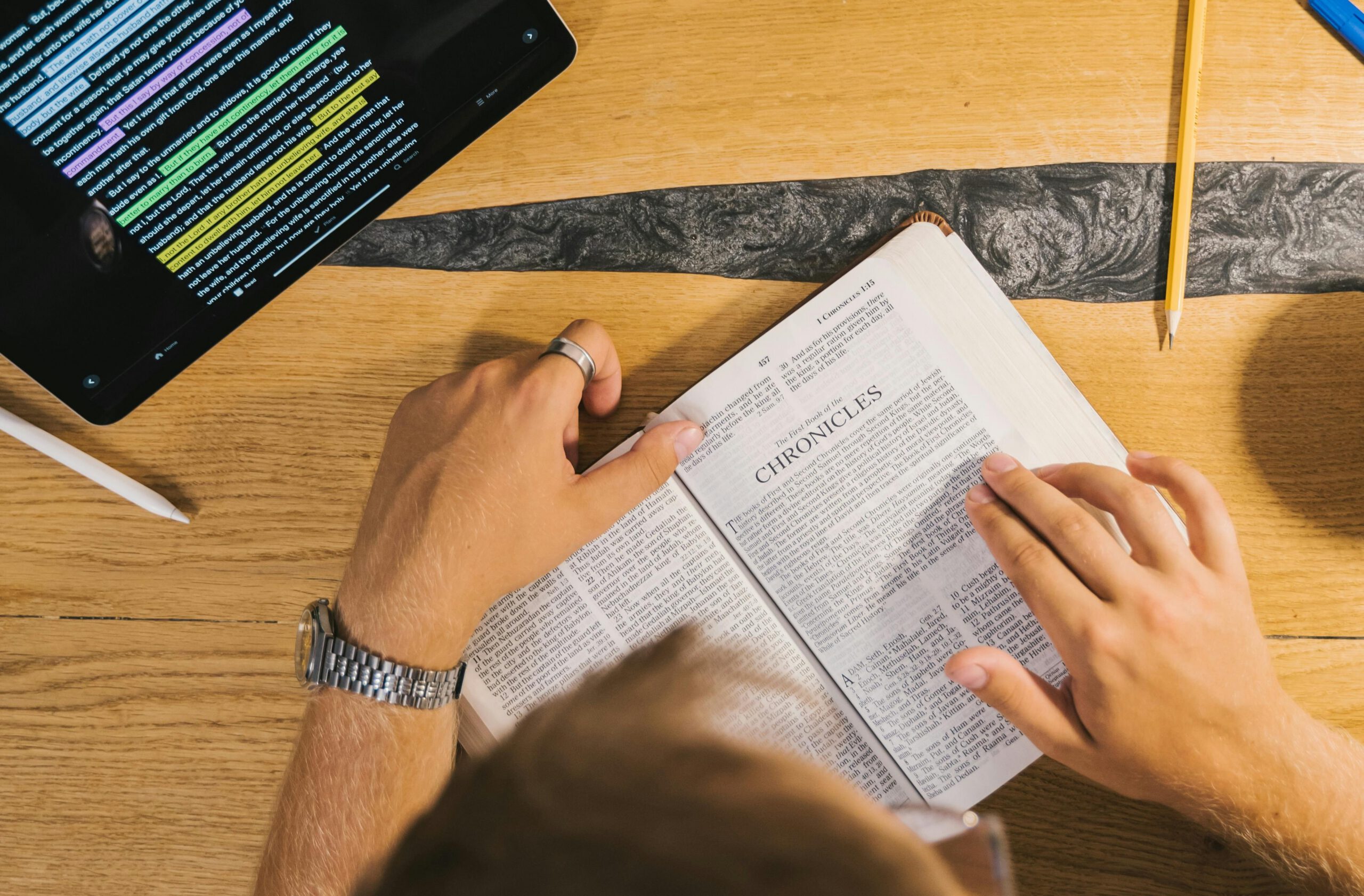 A person studying the Bible with the help of a software tool on their iPad.